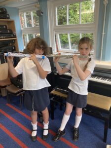Two kids playing flutes